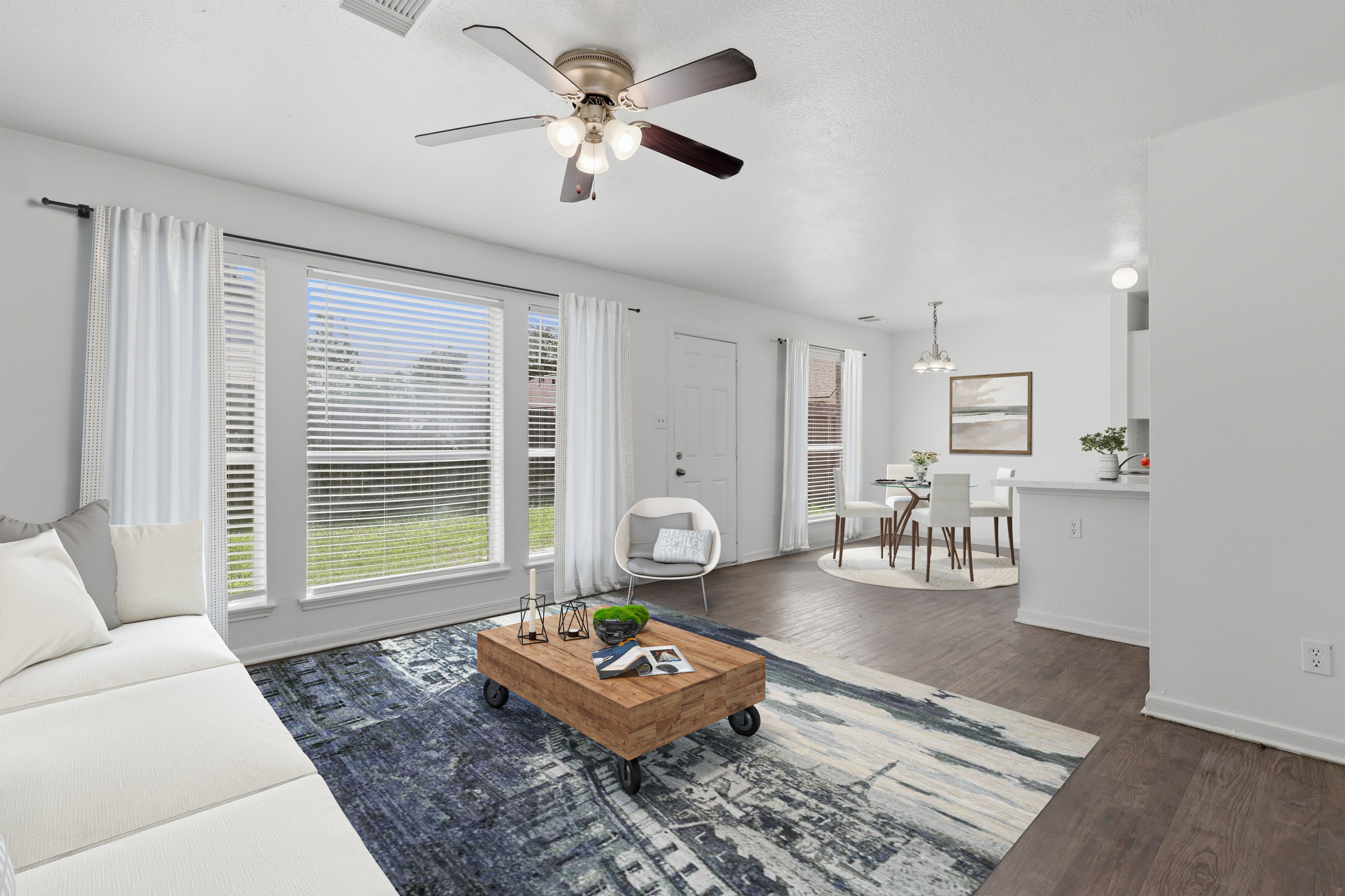 A living room with a white couch and a ceiling fan.